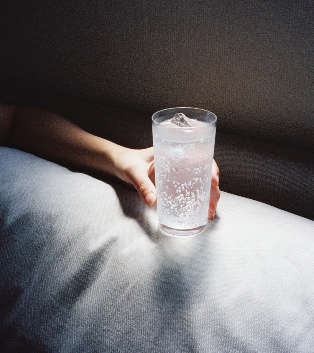 person holding a glass of ice water