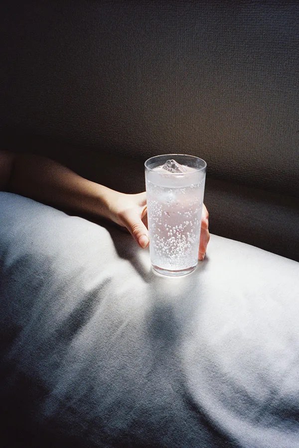 photo of a hand holding a glass of ice water